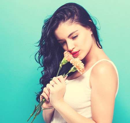 Young woman with flowers on a blue backgroundの写真素材