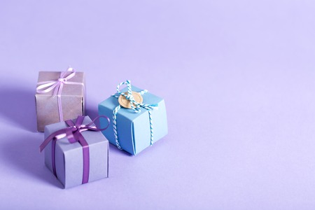 Little handmade present boxes on a purple backgroundの写真素材