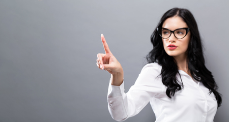 Young woman pointing something on a solid backgroundの写真素材