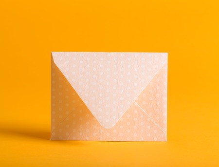 Simple envelope standing on a yellow backgroundの写真素材