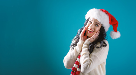 Happy young woman with Santa hat on a solid backgroundの写真素材