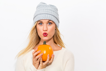 Young blonde woman holding pumpkins for halloweenの写真素材