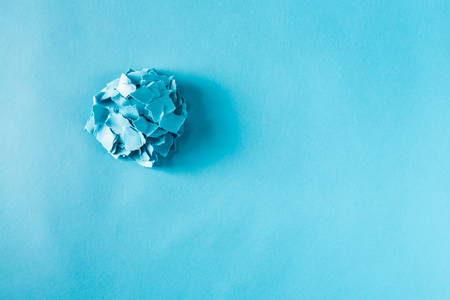 Overhead view of pile of paper pieces on a blue backgroundの写真素材