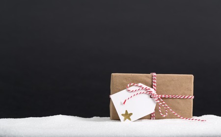 Present box with tag on a black backgroundの写真素材