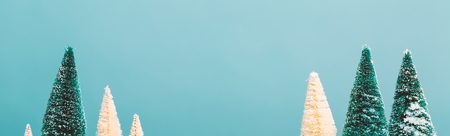 Small green and white Christmas trees in snowの写真素材