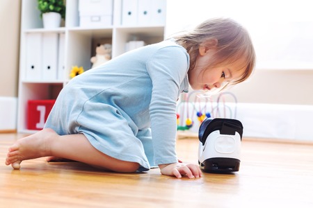 Toddler girl using a virtual reality headset in her houseの写真素材