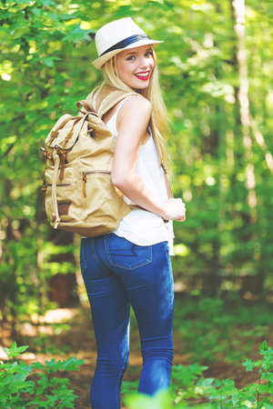 Young woman walking on a forest trail on a beautiful summer dayの写真素材