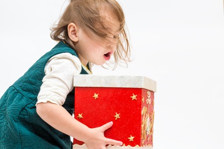 Little girl with Christmas present box on a white backgroundの写真素材