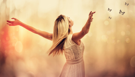 Beautiful woman standing with arms wide openの写真素材