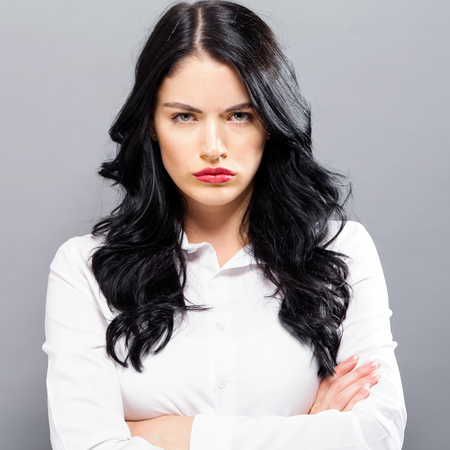 Unhappy young woman on a solid backgroundの写真素材