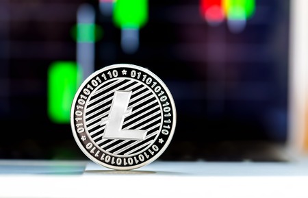 Litecoin crypotocurrency coin with price chart in the backgroundの写真素材