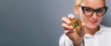 Woman holding a physical bitcoin cryptocurrency in her handの写真素材
