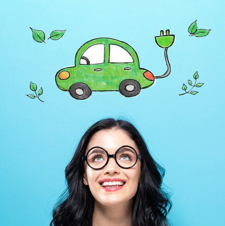 Electric Car with happy young woman on a blue backgroundの写真素材