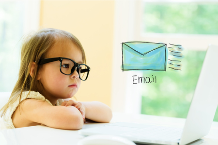 Email with little girl using her laptopの写真素材