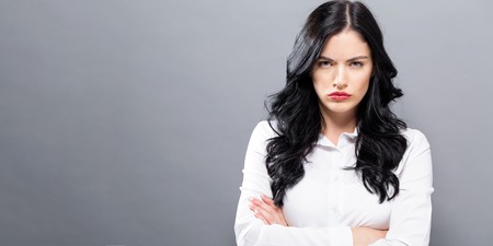 Unhappy young woman on a solid backgroundの写真素材
