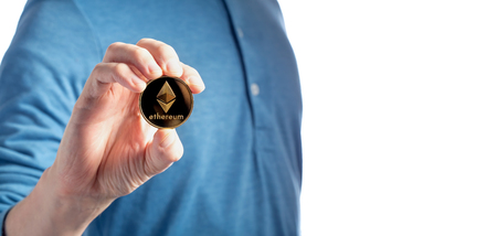 Ethereum cryptocurrency coin held by a man on a white background