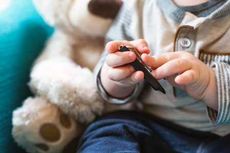 Toddler boy learning to use a nail clipperの写真素材