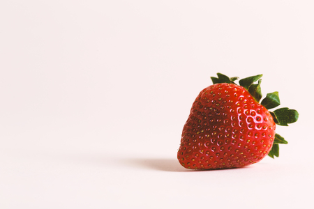 A ripe red strawberry on a cream backgroundの写真素材