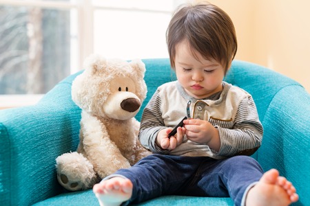 Toddler boy learning to use a nail clipperの写真素材