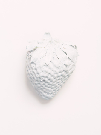 A painted white strawberry on a white backgroundの写真素材