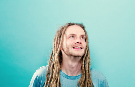Happy young man with dreadlocks on a solid background