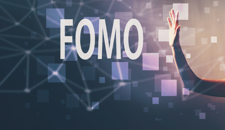FOMO with a hand in a dark light backgroundの写真素材