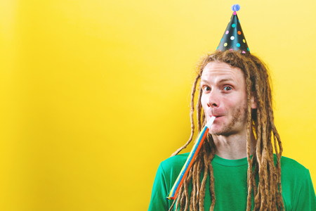 Young man with party theme on a yellow background