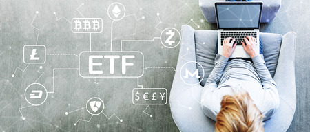 Cryptocurrency ETF theme with man using a laptop in a modern gray chairの写真素材