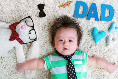 Baby boy celebrating Fathers Day with his stuffed animalsの写真素材