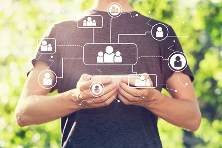 Social connections with young man holding his smartphone outsideの写真素材