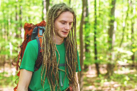 Hiker with a big backpack trekking through the forestの写真素材