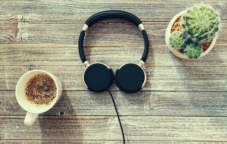 Headphones on a wooden desk overhead viewの写真素材