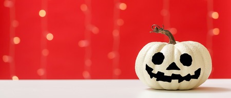 Halloween pumpkin on a shiny light red backgroundの写真素材