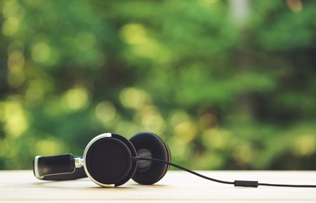 Pair of headphones on a shiny green forest background