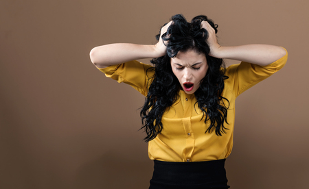 Young woman feeling stressed on a solid backgroundの写真素材