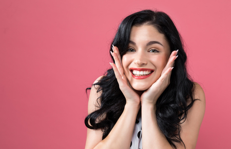 Happy young woman on a solid backgroundの写真素材