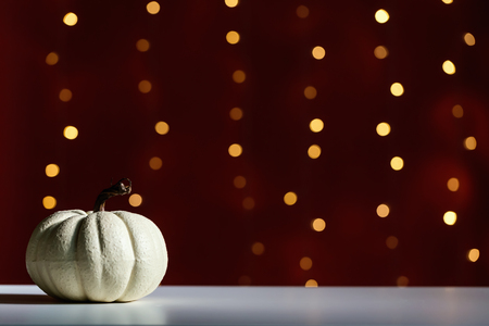 A autumn pumpkin on a shiny light dark red backgroundの写真素材