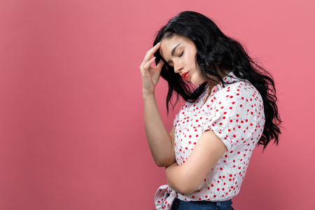 Young woman suffering from head ache on a solid backgroundの写真素材