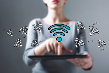 WiFi theme with business woman using a tablet computerの写真素材
