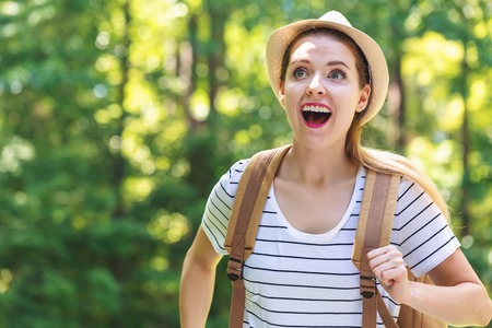 Happy young woman hiking on a bright summer day in the forestの写真素材