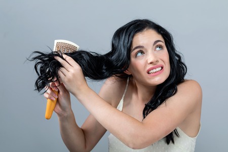 Damaged hair theme with young woman on a gray backgroundの写真素材