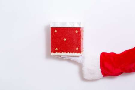 Santa claus holding a red present box on a white backgroundの写真素材