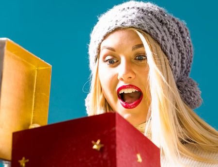 Happy young woman opening a Christmas present box