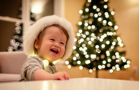 Toddler boy playing with a Santa hat around Christmas timeの写真素材