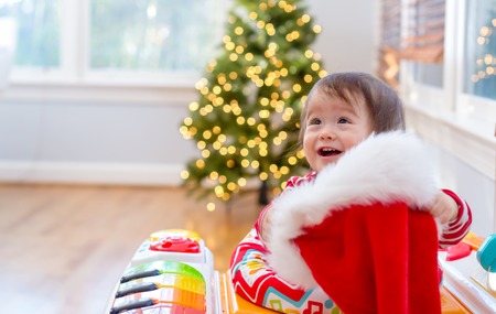 Toddler boy playing with a Santa hat around Christmas timeの写真素材