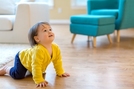 Happy toddler boy playing in his house