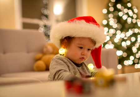 Toddler boy playing with a Santa hat around Christmas timeの写真素材