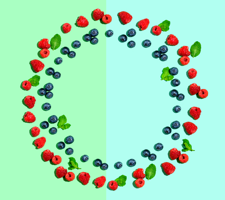 Blueberries and raspberries on a solid color background