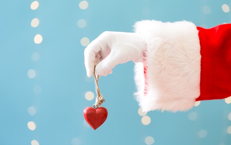 Santa holding a Christmas heart on a shiny light blue backgroundの写真素材
