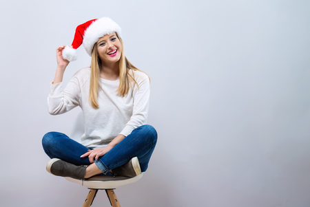 Happy woman with a Santa hat on a gray backgroundの写真素材